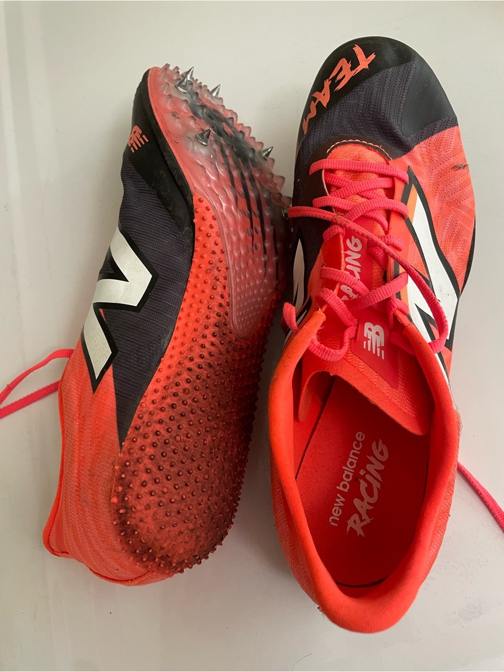 New Balance unisex Racing Spikes in Bright Coral and Black